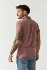 Remera polo blanca con estampado de cruces en color beige, de manga corta, con cuello clásico y cierre de botones.