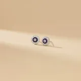 Caravanas tipo stud con diseño de ojo turco en color violeta, rodeado por un borde de circonias brillantes engastadas en plata 925.