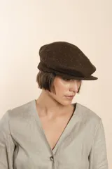 Boina con visera de lana fina uruguaya natural, sin teñir, con diseño de tejido texturizado en tonos beige y marrón.
