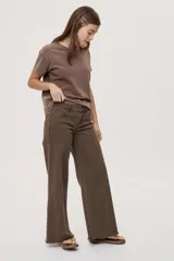 Jean de tiro medio con calce amplio y piernas extra wide leg, color marrón, con diseño de cinco bolsillos, cierre frontal mediante botón y cremallera, y detalle de tachas metálicas en los laterales.