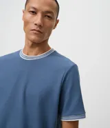 Remera regular de manga corta y cuello redondo color negro, con diseño texturizado y detalles de rayas contrastantes en cuello y puños.