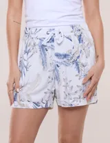 Short de lino con silueta relajada, estampado en tonos azules y tierra sobre fondo blanco. Posee cintura elastizada con cordón ajustable, bolsillos laterales y dobladillo en las piernas.