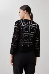Chaqueta corta de crochet color negro, con diseño de cuadrados calados y manga tres cuartos.