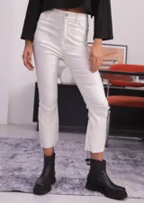 Pantalón de bengalina engomada color blanco, de tiro alto y corte capri semi oxford. Presenta bolsillos traseros, costuras a contratono y un recorte horizontal a la altura de la rodilla.