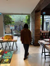 Campera de paño color marrón con diseño de botones frontales, bolsillos laterales y puños con vuelta en tejido de espiga bicolor. Presenta un corte holgado y estructura clásica.