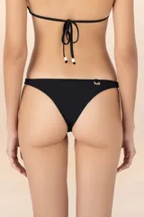 Calzón negro con costuras invisibles, corte a la cadera y cobertura discreta. Presenta pequeños nudos decorativos en los costados.