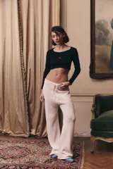 Pantalón de tejido de punto color off white, de corte recto y holgado. Presenta cintura elástica con cordón de ajuste y acabado en rib.