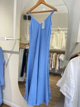 Vestido largo confeccionado en 100% lino de color naranja tierra, con escote en V y tirantes finos. Presenta un diseño fluido y minimalista ideal para la temporada de verano.