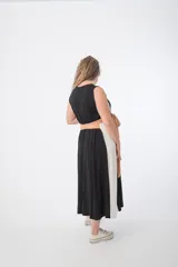 Vestido largo de corte imperio, con paneles verticales en color negro, blanco y ocre. Incluye lazo de tela ocre para ajustar debajo del busto.