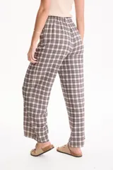 Pantalón ancho de lino con estampado en blanco y negro, cintura elástica con cordón de ajuste y bolsillos laterales.