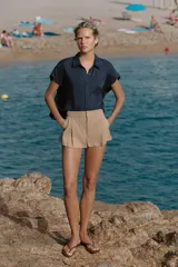 Shorts de tiro medio con bolsillos laterales y detalle de pinzas delanteras. Cierre frontal con cremallera, botón interior y gancho metálico.