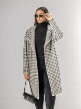 Sacón tipo tapado de corte recto y largo midi, con diseño de estampa pied de poule y solapas clásicas. Confeccionado en tejido abrigado y liviano, ideal para media estación.