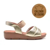 Sandalia de cuero dorada con plataforma marrón, tira ancha acolchada sobre el empeine y tira elástica en el tobillo.