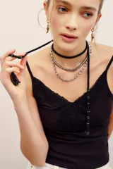 Collar largo negro de cuentas de resina con detalles en latón, diseñado para usar con múltiples vueltas alrededor del cuello.