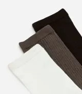Kit de tres pares de medias de caña alta con textura acanalada, confeccionadas en tejido de algodón suave y elástico.