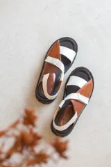 Sandalias de plataforma con suela track, confeccionadas en una combinación de cuero liso y cuero con textura croco. Presentan tiras anchas en el empeine y cierre con hebilla ajustable en el talón.