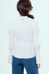 Camisa blanca de manga larga con diseño abullonado y puños fruncidos, detalle de nido de abeja en el frente y cuello alto con volados.