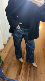 Pantalón de tafeta elastizada con estampado floral en tonos azules, bordó y verde.