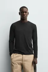 Camiseta slim fit de manga larga y cuello redondo, confeccionada en tejido de algodón elastizado de color marrón oscuro.
