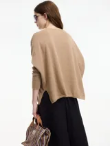 Sweater color beige de hilo con textura brillosa, escote en V y manga larga.