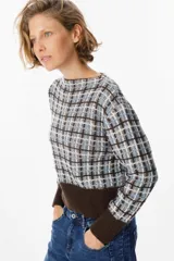 Sweater de punto con diseño de cuadros en tonos marrón, celeste y blanco. Presenta cuello redondo, mangas largas y un diseño de tejido acanalado en el ruedo y los puños en color marrón sólido.