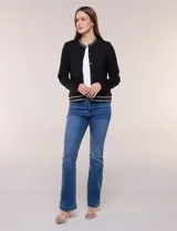 Cardigan tipo varsity negro de punto liviano, con cuello redondo, mangas largas y cierre frontal de botones. Presenta detalles de líneas blancas en el cuello, los bolsillos simulados y el ruedo elástico acanalado.