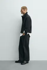 Sobrecamisa de corte regular fit color negro con pespuntes en contraste blancos. Presenta cuello solapa, mangas largas con puños abotonados, bolsillos frontales de vivo y cierre de cremallera oculta por solapa con botones.
