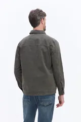 Sobrecamisa de canvas color beige con efecto lavado, de estructura firme y manga larga. Presenta cuello clásico, cierre frontal con botones y un bolsillo frontal en el pecho.