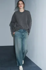 Jeans de tiro medio, corte recto y ancho, en denim azul claro con efecto lavado y desgaste. Presenta cierres metálicos completos a lo largo de las costuras laterales exteriores de ambas piernas.