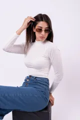 Body de manga larga en color marrón, confeccionado en tejido acanalado con cuello alto. Presenta un ajuste al cuerpo y cierre inferior.