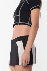 Remera corta color lila con cuello alto, mangas cortas y costuras a la vista.