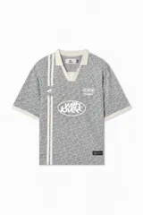 Polo Scuffers de corte boxy fit en color gris, con diseño texturizado monograma, cuello polo y detalles en blanco marfil en cuello, puños y bandas verticales. Confeccionado en tela microperforada y ultra respirable.