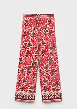 Pantalón largo de corte recto y tejido fluido, con estampado paisley en tonos rojo, bordó y crudo. Cuenta con cintura elástica con cordón ajustable y bolsillos laterales.