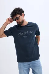Remera de algodón color azul oscuro con efecto lavado, cuello redondo, mangas cortas y estampa tipográfica frontal con la frase "The Old Market".