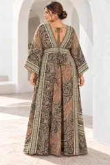 Vestido largo de estilo bohemio, color azul con estampado floral en tonos blancos y detalles geométricos en el escote y la cintura. Posee escote en V con cordones ajustables, mangas amplias tipo kimono y una silueta fluida y holgada.