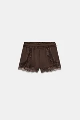 Shorts de tiro bajo confeccionados en satén color marrón, con cintura elástica y detalles de encaje a tono en los laterales y el ruedo.