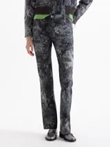 Pantalón de gabardina con corte jeanero y estampado damasco en tonos grises. Presenta bolsillos delanteros curvos con bolsillo relojero, bolsillos traseros plaqué y cierre frontal con broche metálico.