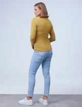 Buzo rojo de tejido fino con cuello redondo y mangas largas. Detalle de botones dorados en los puños.