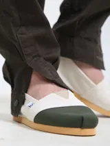 Alpargata de lona color crudo con puntera verde y suela de goma color caramelo.