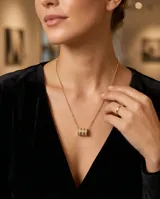 Collar de acero con baño de oro, compuesto por una cadena fina y un dije central formado por tres anillos circulares entrelazados con incrustaciones de circonias.