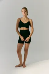 Top deportivo de tejido acanalado con escote en V y breteles finos regulables. Diseño sin costuras con ajuste al cuerpo.