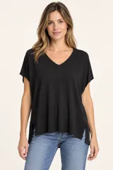 Remera de punto color negro, con escote en V ribeteado, mangas cortas caídas y aberturas laterales en el dobladillo.