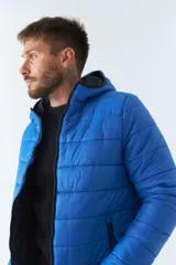 Campera puffer azul eléctrico, reversible, con cuello alto, cierre frontal con cremallera, bolsillos laterales con cierre y logo de goma en el pecho.