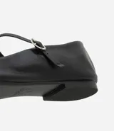 Bailarina de cuero color marrón con puntera cuadrada, taco plano y tira ajustable con hebilla metálica sobre el empeine.