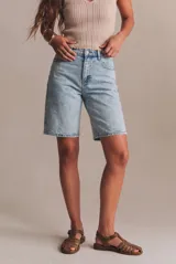 Bermuda de denim de tiro medio en color celeste claro lavado, corte recto y largo midi, con cinco bolsillos y cierre frontal con botón y cremallera.