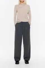 Pantalón de vestir gris oscuro, de corte ancho y tiro alto, con cintura elástica y pliegues frontales.