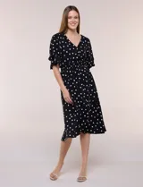 Vestido midi de calce holgado y caída fluida con escote en V cruzado, cintura elastizada fruncida y mangas cortas con volados superpuestos. Cuenta con un diseño estampado de flores grandes en tonos amarillo, blanco, azul marino y verde.