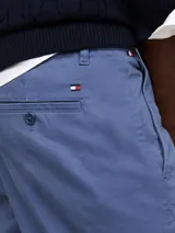 Pantalón chino azul de corte cónico, confeccionado en satén de algodón elástico.