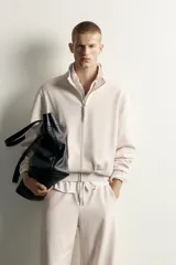 Chaqueta relaxed fit color beige melange, con cuello subido, manga larga y cierre frontal de cremallera. Cuenta con bolsillos de vivo en la cadera y acabados en rib.