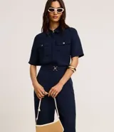 Pantalón zanahoria color fucsia de tiro alto, confeccionado en tejido airflow, con cintura elastizada, trabillas y hebillas metálicas.